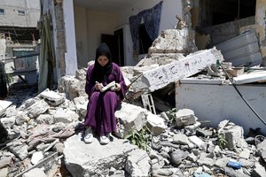 Artist Saja Moussa draws on broken tiles while sitting on the rubble of her family destroyed house in Rafah refugee camp, southern Gaza Strip, Tuesday, June 15, 2021.