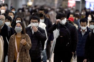 A station passageway is crowded with face mask wearing commuters during a rush hour, in Tokyo