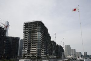 Japanese flag flies next to the construction site of the Tokyo Olympic Village in Tokyo. Japan