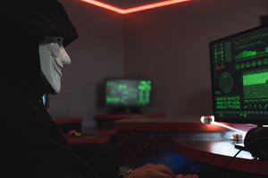 Person with Anonymous mask using computer