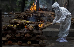 A relative lights the funeral pyre of a COVID-19 victim in Gauhati, India, Friday, July 2, 2021