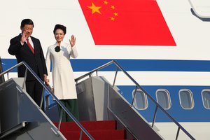 Xi Jinping and his wife Peng Liyuan walk down the plane upon their arrival