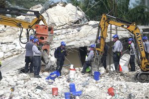 Rescue crews work at the site of the collapsed Champlain Towers South condo building after the remaining structure was demolished Sunday, in Surfside