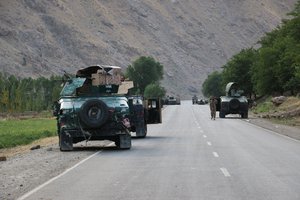 Afghan soldiers pause on a road at the front line of fighting between Taliban and Security forces, near the city of Badakhshan, northern Afghanistan, Sunday, July. 4, 2021.