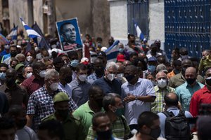 Cuba's President Miguel Diaz Canel walks with his followers after an anti-government protest in San Antonio de los Banos, Cuba, Sunday July 11, 2021