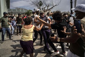 Police scuffle and detain an anti-government demonstrator during a protest in Havana, Cuba, Sunday July 11, 2021.