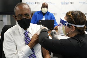 Patrick Range Sr., 81, receives the Pfizer-BioNTech COVID-19 vaccine from registered nurse Susana Flores Villamil at Jackson Memorial Hospital, Wednesday, Dec. 30, 2020, in Miami.