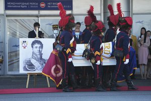 People dressed in historical costumes of French Army carry the coffin that contains the remains of Charles-Etienne Gudin, Napoleon-era France general who died after he was hit by a cannonball near Smolensk during the French invasion of Russia in 1812, at Vnukovo International Airport outside Moscow, Russia, Tuesday, July 13, 2021