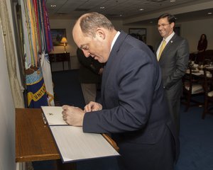 Ben Wallace, signs the guest book in a meeting with Defense Secretary Dr. Mark T. Esper, at the Pentagon