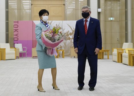 Tokyo Governor Yuriko Koike, left, and International Olympic Committee President Thomas Bach, right, pose for photos prior to their meeting in Tokyo, Japan Thursday, July 15, 2021.