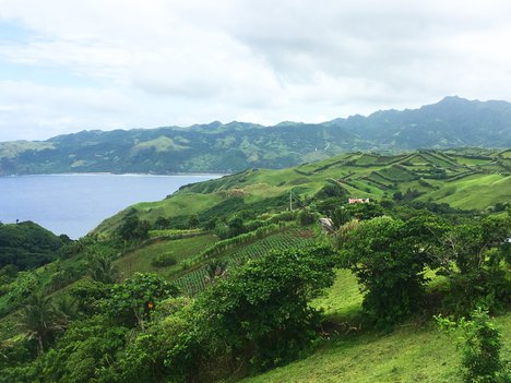 Lush mountains open to ocean breeze and vast skies in Batanes, Philippines.