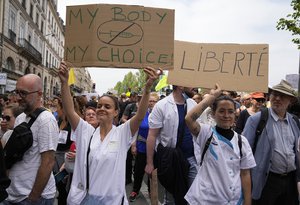 Nurses hold placards as they march during an anti-vaccine protest in Paris, Saturday, July 17, 2021. Tens of thousands of people protested across France on Saturday against the government's latest measures to curb rising COVID-19 infections and drive up vaccinations in the country.