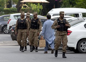 File - Pakistani soldiers patrol in a parking lot of the hotel where British royal couple stays, in Islamabad, Pakistan, Tuesday, Oct. 15, 2019.