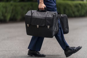 A U.S. military aide carries the "President's emergency satchel," also know as "the football," with the nuclear launch codes, walks towards Marine One on the South Lawn of the White House in Washington, Tuesday, July 13, 2021