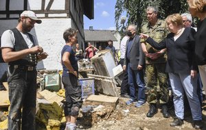 German Chancellor Angela Merkel, right, talks to residents during a visit to the flood-damaged village of Schuld near Bad Neuenahr-Ahrweiler, Germany, Sunday July 18, 2021