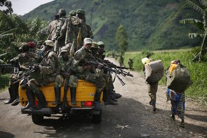 In this November 30, 2012 file photo, M23 rebels withdraw from the Masisi and Sake areas in eastern Congo. Fighting between M23 rebels and the army continued for a second day Tuesday, May 21, 2013, near Congo's eastern provincial capital of Goma, in clashes that have so far killed 20 people, all of them either soldiers or rebels, officials said.