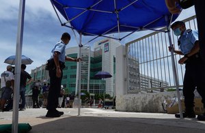 Police officers set up a tent outside the Apple Daily headquarters as Hong Kong media tycoon Jimmy Lai, who founded the local newspaper Apple Daily, was arrested by police officers at his home in Hong Kong, Monday, Aug. 10, 2020.