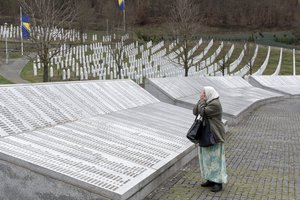 FILE - In this Wednesday, March 20, 2019 file photo, a woman prays at the Potocari memorial center for victims of the Srebrenica genocide, in Potocari, Bosnia and Herzegovina.