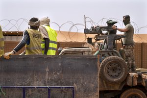 In this Monday June 7, 2021 file photo, French Barkhane force commandos mount a machine gun on a camouflaged pickup as Malian workers drive by before heading on a mission from their base in Gao, Mali, combatting al-Qaida and the Islamic State in Africa’s Sahel region.