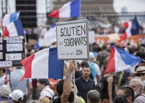 A banner that reads: "Support to health workers and not only at 8pm", is held up during a demonstration in Paris, France, Saturday 24, 2021