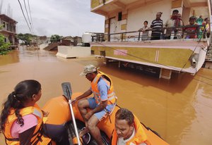 People stranded in flood waters watch others being rescued at Kolhapur in western Maharashtra state, India, Saturday, July 24, 2021