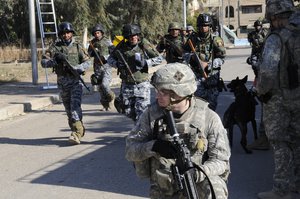 U.S. Army Spc. Jacob Hubbard from Fort Dodge, Iowa, and U.S. Soldiers from 3rd Battalion, 29th Field Artillery, 3rd Brigade, 4th Infantry Division, pulls security for Iraqi soldiers along with Iraqi national police while conducting a neighborhood cordon and search during Operation Lion Tornado on Dec. 15, 2008 in Baghdad, Iraq.