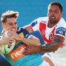 Gold Coast’s AJ Brimson tries to escape the Dragons’ Gerard Beale.