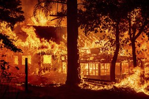 Flames from the Dixie Fire consume a home in the Indian Falls community of Plumas County, Calif., Saturday, July 24, 2021