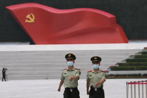 File - Chinese paramilitary police march near a sculpture of the Chinese Communist Party flag outside the Museum of the Communist Party of China in Beijing on Wednesday, June 23, 2021.