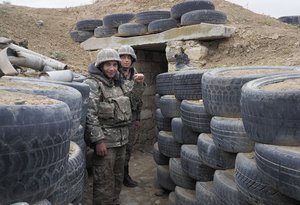 Ethnic Armenian soldiers stand at a fighting position on the front line, during a military conflict against Azerbaijan's armed forces in the separatist region of Nagorno-Karabakh, Wednesday, Oct. 21, 2020.