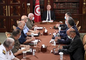 Tunisia's President Kais Saied, center, leads a security meeting with members of the army and police forces in Tunis, Tunisia, Sunday, July 25, 2021