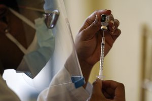 A pharmacist with Walgreens Pharmacy prepares a syringe with the Pfizer-BioNTech COVID-19 vaccine for residents and staff at the The Palace assisted living facility, Tuesday, Jan. 12, 2021