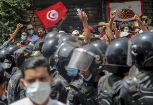 File - In this July 25, 2021 file photo, protesters face Tunisian police officers during a demonstration in Tunis, Tunisia.