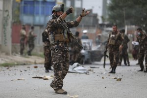 Security personnel inspect a damaged vehicle which was was firing rockets in Kabul, Afghanistan, Tuesday, July 20, 2021