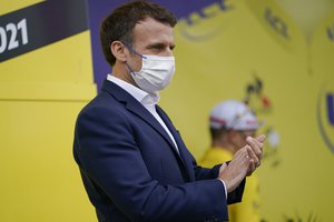 French President Emmanuel Macron attends the podium ceremony applauds for overall leader Slovenia's Tadej Pogacar, rear, after the eighteenth stage of the Tour de France cycling race over 129.7 kilometers (80.6 miles) with start in Pau and finish in Luz Ardiden, France,Thursday, July 15, 2021