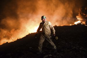 Firefighters try to get the fire under control in Kirli village near the town of Manavgat, in Antalya province, Turkey early Friday July 30, 2021. The fire that continued all night could not be brought under control and people living in the village started to evacuate.