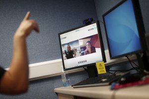 In this Thursday, May 14, 2020 photo, Speech and Language Therapist Alison McLoughlin conducts a therapy session with a patient using the Zoom app in the Ear