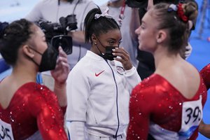 Simone Biles, of the United States, stands with teammates after she exited the team final with apparent injury, at the 2020 Summer Olympics, Tuesday, July 27, 2021, in Tokyo