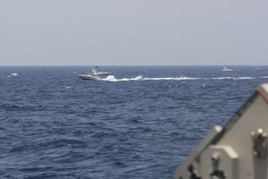 In this image provided by the U.S. Navy, an Iranian Islamic Revolutionary Guard Corps Navy (IRGCN) fast in-shore attack craft (FIAC), a type of speedboat armed with machine guns, speeds near U.S. naval vessels transiting the Strait of Hormuz, Monday, May 10, 2021