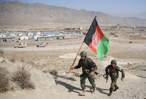 An Afghan National Army soldier carries a flag during a military training exercise at Kabul Military Training Center, in Kabul, Afghanistan, Wednesday, Oct. 22, 2014.