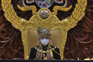 This handout photo from Malaysia's Department of Information taken and released on May 18, 2020 shows Malaysi’s King Sultan Abdullah Sultan Ahmad Shah, centre, pray during the opening ceremony of the third term of the 14th parliamentary session at parliament house in Kuala Lumpur.  Malaysia’s parliament held an unusual half-day sitting Monday, that was kept short due to the COVID-19 pandemic and saw Prime Minister Muhyiddin Yassin dodge a vote of no-confidence against him over two months since he came into power.(Nazri Rapai/ Malaysia's Department of Information via AP)