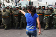 URUMQI, CHINA - JULY 07:  An Uighur woman gestures as she protests in front of policemen on July 7, 2009 in Urumqi, the capital of Xinjiang Uighur autonomous region, China. Hundreds of Uighur people have taken to the streets protesting after their relatives were detained by authorities after Sunday’s protest.  Ethnic riots in the capital of the Muslim Xinjiang region on Sunday saw 156 people killed. Police officers, soldiers and firefighters were dispatched to contain the rioting with hundreds of people being detained.  (Photo by Guang Niu/Getty Images) Getty image for Traveller. Single use only.