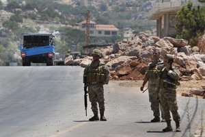 Lebanese army soldiers stand next to a rocket launcher placed on a pick up truck that was used by Hezbollah to fire rockets near Israeli positions, in the southeastern village of Shwaya, near the border with the Golan Heights, Friday, Aug. 6, 2021