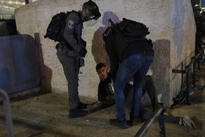 Israeli police detain a Palestinian youth at the Damascus Gate to the Old City of Jerusalem after clashes at the Al-Aqsa Mosque compound, Friday, May 7, 2021.