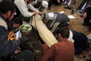 Afghan men bury a victim of bombings on Saturday near a school, west of Kabul, Afghanistan, Sunday, May 9, 2021. The Interior Ministry said the death toll in the horrific bombing at the entrance to a girls' school in the Afghan capital has soared to some 50 people, many of them pupils between 11 and 15 years old.