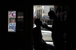 File photo: A Lebanese barber shaves the beard of a customer at the door of his shop during a power outage in a southern suburb of Beirut, Lebanon, Wednesday, Aug. 11, 2021