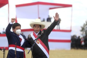 Peru's President Pedro Castillo, right, and his Prime Minister Guido Bellido pose for photos after a symbolic swearing-in ceremony at the site of the 1824 Battle of Ayacucho, which sealed independence from Spain, at the Pampa de la Quinua as part of Peru´s bicentennial celebrations in Ayacucho, Peru, Thursday, July 29, 2021, the day after he was officially sworn in as president.