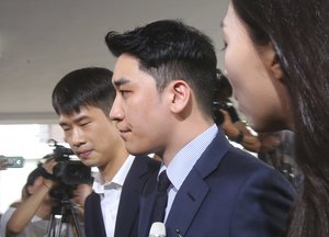 Seungri, center, a former member of the popular K-pop boy band Big Bang, arrives at the Seoul Metropolitan Police Agency's Intelligence Criminal Investigation Squad in Seoul, South Korea, Wednesday, Aug. 28, 2019.