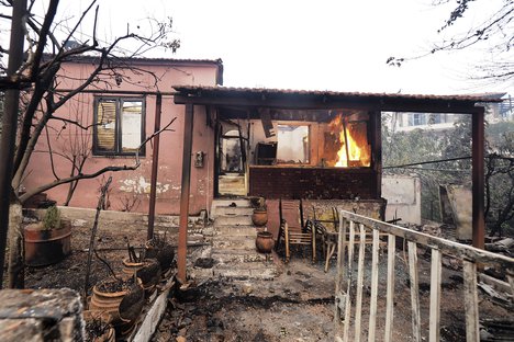 A fire burns a house in Rovies village on the island of Evia, about 160 kilometers (100 miles) north of Athens, Greece, Wednesday, Aug. 4, 2021