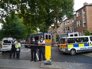 Police officers keep guard around Parsons Green subway station in London, England, UK